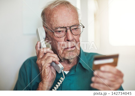 Senior man, telephone and call with credit card for banking, finance or reading instruction on account at home. Elderly male person talking with debit in financial problem, retirement or pension fund 142734045