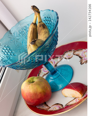 A banana and an apple on a plate. 142734166