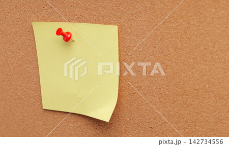 Blank yellow paper sheet mockup pinned on corkboard texture background for message and note 142734556