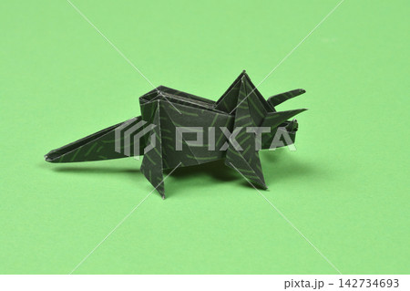 Origami triceratops dinosaur on green background Origami triceratops dinosaur on green background 142734693