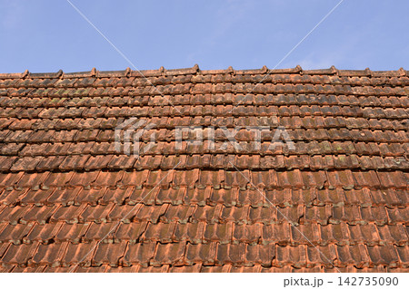 Old clay tile roof against blue sky Old clay tile roof against blue sky 142735090