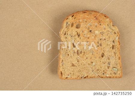 Toasted Whole Grain Bread Slice on Brown Background Toasted Whole Grain Bread Slice on Brown Background 142735250