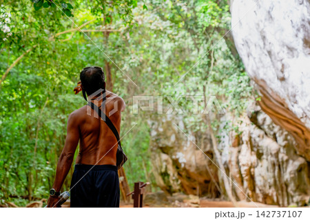 Man exploring natural jungle caves and rock formations Man exploring natural jungle caves and rock formations 142737107