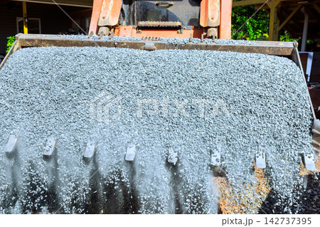 Heavy machinery spreads gravel at construction site Heavy machinery spreads gravel at construction site 142737395