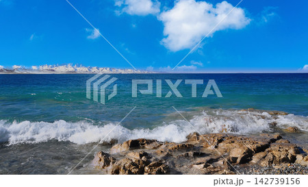 Tibetan Plateau Landscape with Snow Capped Mountains and Lake Shoreline 142739156