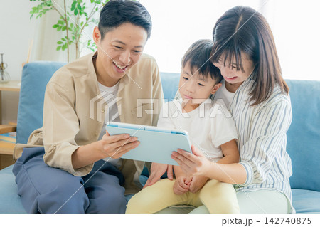 リビングでタブレットを見る家族 リビングでタブレットを見る家族 142740875