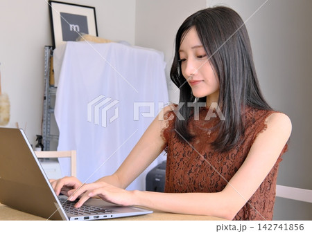 デスクでパソコンを操作する若い女性（テレワーク・ビジネス・作業イメージ） 142741856