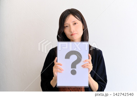 疑問や質問を意味するクエスチョンマークの紙を持つ若い女性(Q&A・お悩み・比較のイメージ) 疑問や質問を意味するクエスチョンマークの紙を持つ若い女性(Q&A・お悩み・比較のイメージ) 142742540