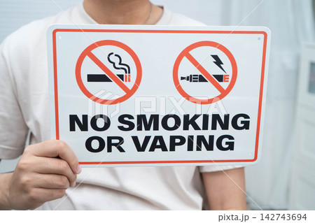Male holding a no smoking or vaping sign. Male holding a no smoking or vaping sign. 142743694