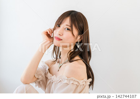 カメラ目線で微笑む若い女性。美しい肌と髪をイメージしたビューティーポートレート カメラ目線で微笑む若い女性。美しい肌と髪をイメージしたビューティーポートレート 142744107