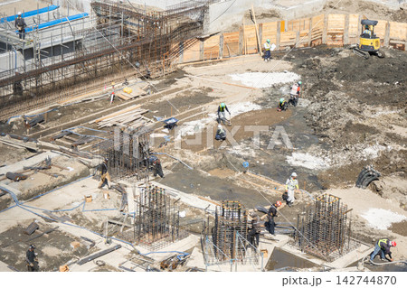 大型建築物の基礎工事現場で位置と寸法を測定する作業員 大型建築物の基礎工事現場で位置と寸法を測定する作業員 142744870