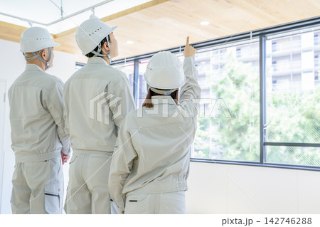 現場で打ち合わせをする作業着の男性と女性 現場で打ち合わせをする作業着の男性と女性 142746288