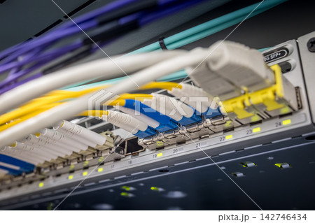 Close-up of multiple colored fiber optic LC connectors and network cables connected to 10G SFP plus switch ports in a professional data center server rack Close-up of multiple colored fiber optic LC connectors and network cables connected to 10G SFP plus switch ports in a professional data center server rack 142746434