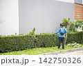 A Gardening with a brushcutter in the day time, focus selective. 142750326