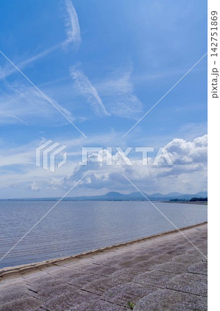 青空に白い夏雲が広がる穏やかな海辺とコンクリート防波堤の風景 青空に白い夏雲が広がる穏やかな海辺とコンクリート防波堤の風景 142751869