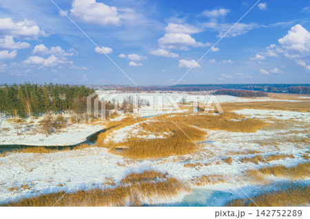 Rural landscape in winter. View from above of forest and brook on the meadow. Nature background Rural landscape in winter. View from above of forest and brook on the meadow. Nature background 142752289