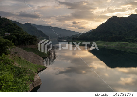 夕空と山並みが静かな水面に映り込む八ッ場ダムの夕暮れ風景 142752778