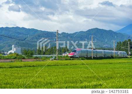 秋田県の水田を駆け抜ける秋田新幹線こまち 緑の田園と鉄道の風景 142753181