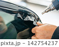 A car wrapping specialist applies a polyurethane film to the car. Detailer PPF 142754237