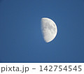 Crescent moon hangs in deep blue sky 142754545