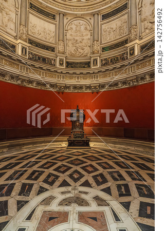 Elliptical domed chapter house of Seville Cathedral with red damask walls and archbishop's throne 142756492