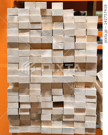 Boards, wooden slats, timber planks and other wood products stored on metal shelves in a construction supermarket Boards, wooden slats, timber planks and other wood products stored on metal shelves in a construction supermarket 142757419