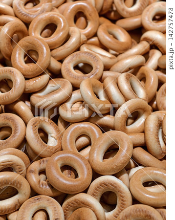 Fresh crispy bagels piled together on a supermarket bakery display, showcasing baked products presented attractively as part of the available selection Fresh crispy bagels piled together on a supermarket bakery display, showcasing baked products presented attractively as part of the available selection 142757478