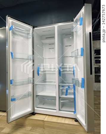Double-door refrigerator with both doors open, offering a clean and organized interior for your food 142757673