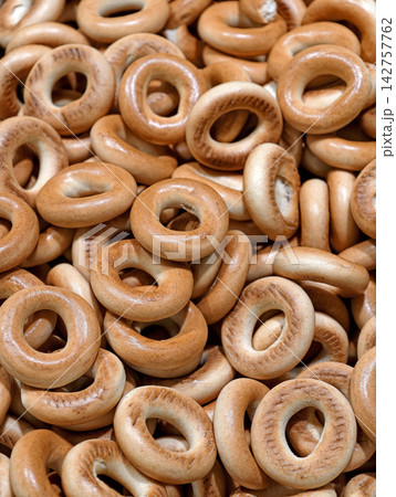 Fresh crispy bagels displayed among bakery products in a supermarket, showcasing baked goods piled together and presented attractively for customers and shoppers Fresh crispy bagels displayed among bakery products in a supermarket, showcasing baked goods piled together and presented attractively for customers and shoppers 142757762