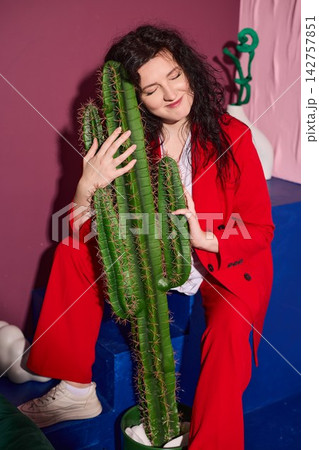 Serene woman in cozy space with peaceful cactus presence Serene woman in cozy space with peaceful cactus presence 142757851