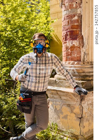 Person taking break while assessing construction tools outside Person taking break while assessing construction tools outside 142757855