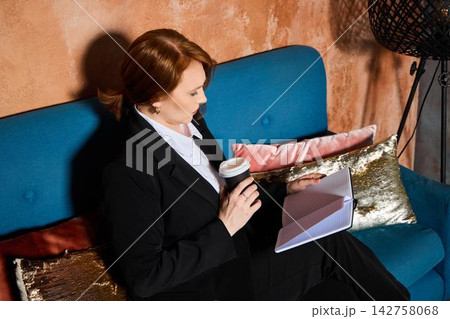 Relaxed woman with coffee notes. She takes quiet moment for herself Relaxed woman with coffee notes. She takes quiet moment for herself 142758068