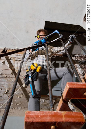Worker assessing environment with equipment and safety gear Worker assessing environment with equipment and safety gear 142758087