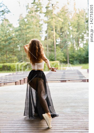 Serene figure gliding onto verdant greenery softly illuminated by dusk 142758305