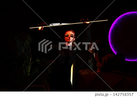 Spectacular entertainer illuminated by vibrant colors and dramatic scene 142758357