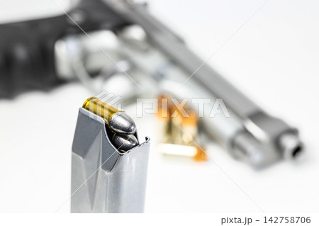 bullet 9mm parabellum LRN ( lead round nose ) in magazines and 9mm postal gun in background. bullet 9mm parabellum LRN ( lead round nose ) in magazines and 9mm postal gun in background. 142758706