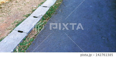 Asphalt Road with Concrete Drainage Gutter and Grass Edge Asphalt Road with Concrete Drainage Gutter and Grass Edge 142761385