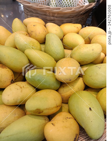 Ripe mango fruit piled in market basket with fresh tropical produce 142761608