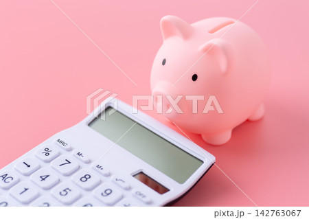 豚の貯金箱と白い電卓 ピンクバック 豚の貯金箱と白い電卓 ピンクバック 142763067