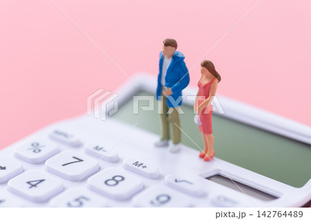 若いカップルの人形と白い電卓 ピンクバック 若いカップルの人形と白い電卓 ピンクバック 142764489