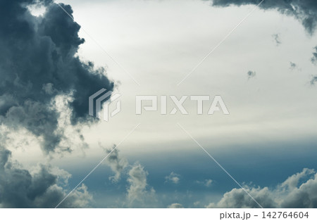 Dramatic dark storm clouds surrounding opening in sky, atmospheric cloudscape suggesting changing weather, approaching storm, nature, uncertainty and climate. Weather background for climate, rainfall. Dramatic dark storm clouds surrounding opening in sky, atmospheric cloudscape suggesting changing weather, approaching storm, nature, uncertainty and climate. Weather background for climate, rainfall. 142764604