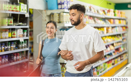 Married couple walks through supermarket and chooses food 142765103