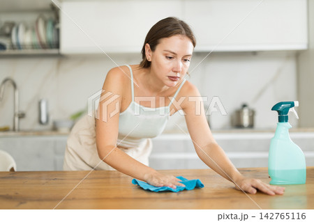 Adult woman in shorts cleaning kitchen Adult woman in shorts cleaning kitchen 142765116