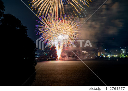 長崎県大村市での花火大会の夜景。夜空を彩る壮大な光と水面に映る反射が美しい夏の風景。 142765277