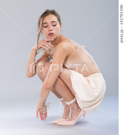 Topless young woman posing in in bright minimalist studio environment Topless young woman posing in in bright minimalist studio environment 142765390