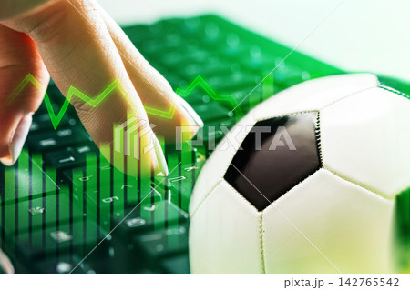 Football betting on a computer with a soccer ball and betting graphs in the background 142765542