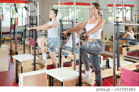 Young woman engaged in leg workouts on combo chair Young woman engaged in leg workouts on combo chair 142765865