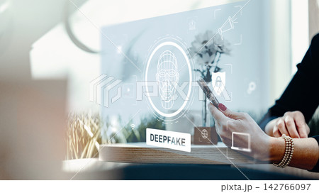 Deep fake technology shown on a screen while a person uses a phone in a modern workspace Deep fake technology shown on a screen while a person uses a phone in a modern workspace 142766097