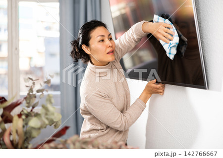 Woman washing TV monitor during cleanup Woman washing TV monitor during cleanup 142766667