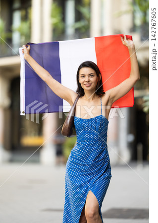 Young woman with french flag on city street Young woman with french flag on city street 142767605